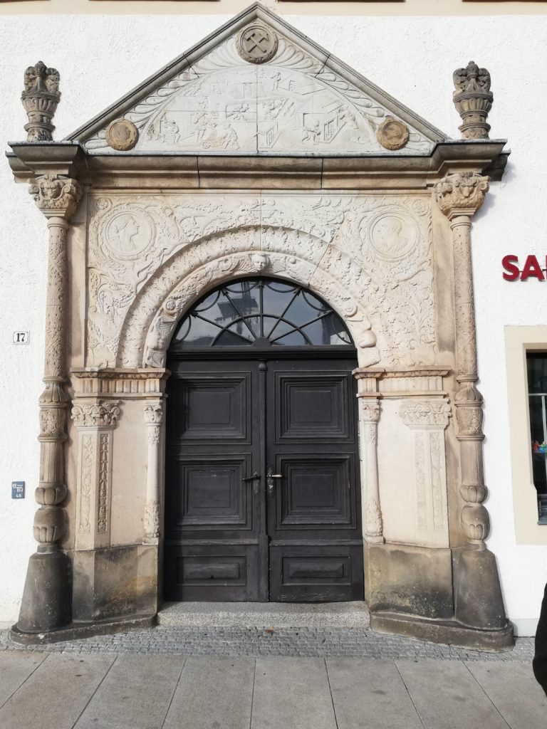 The ornamented door with hammer and chisel motto
