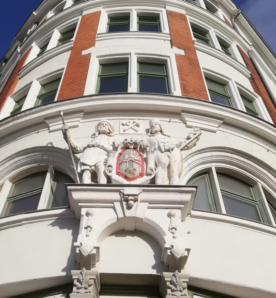 The mining symbol and the miners sculpted above the door of a building