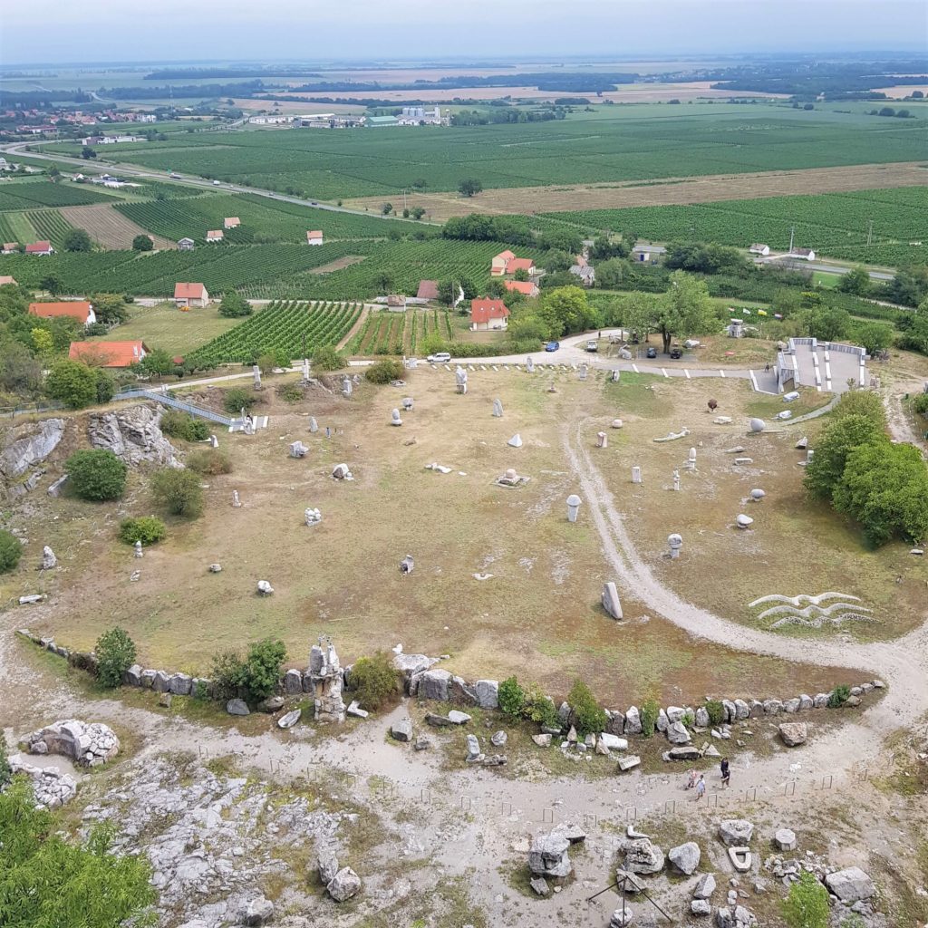 View from top of the quarry featuring stone statues and wineyards