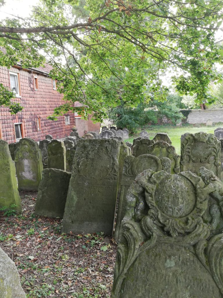 The image depicts the condition of the Jewish cemetery